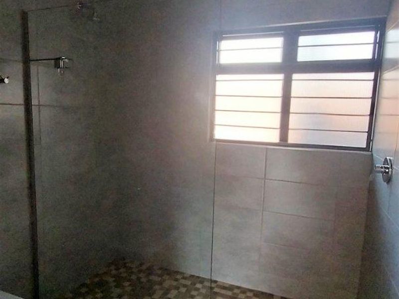 A modern bathroom featuring a spacious walk-in shower with a glass screen, tiled flooring, and neutral wall finishes.