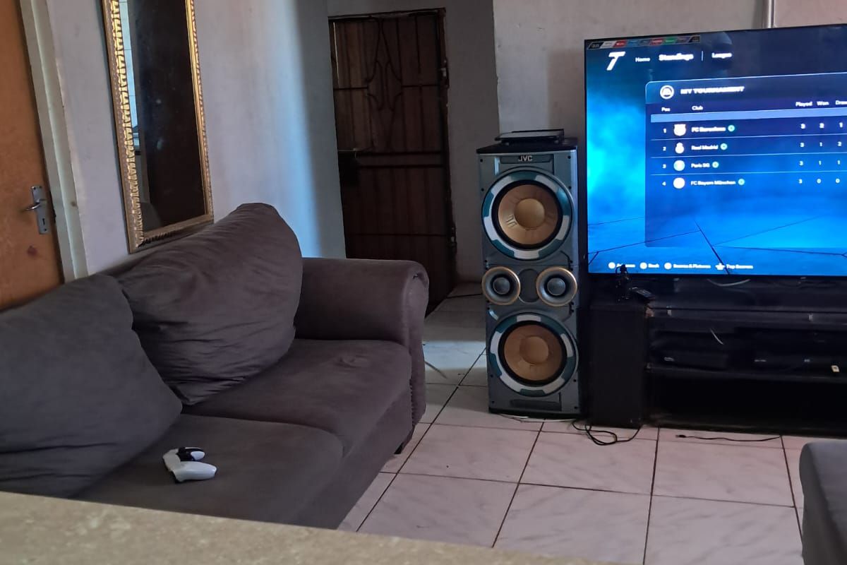 Living room area featuring tiled flooring and decorative ceiling tiles, requiring cosmetic updates to improve the overall aesthetic and finish.