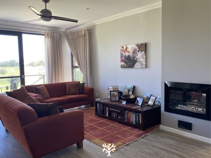 A comfortable living room featuring a modern built-in fireplace, ceiling fan, and large sliding glass doors that provide natural light and outdoor access.
