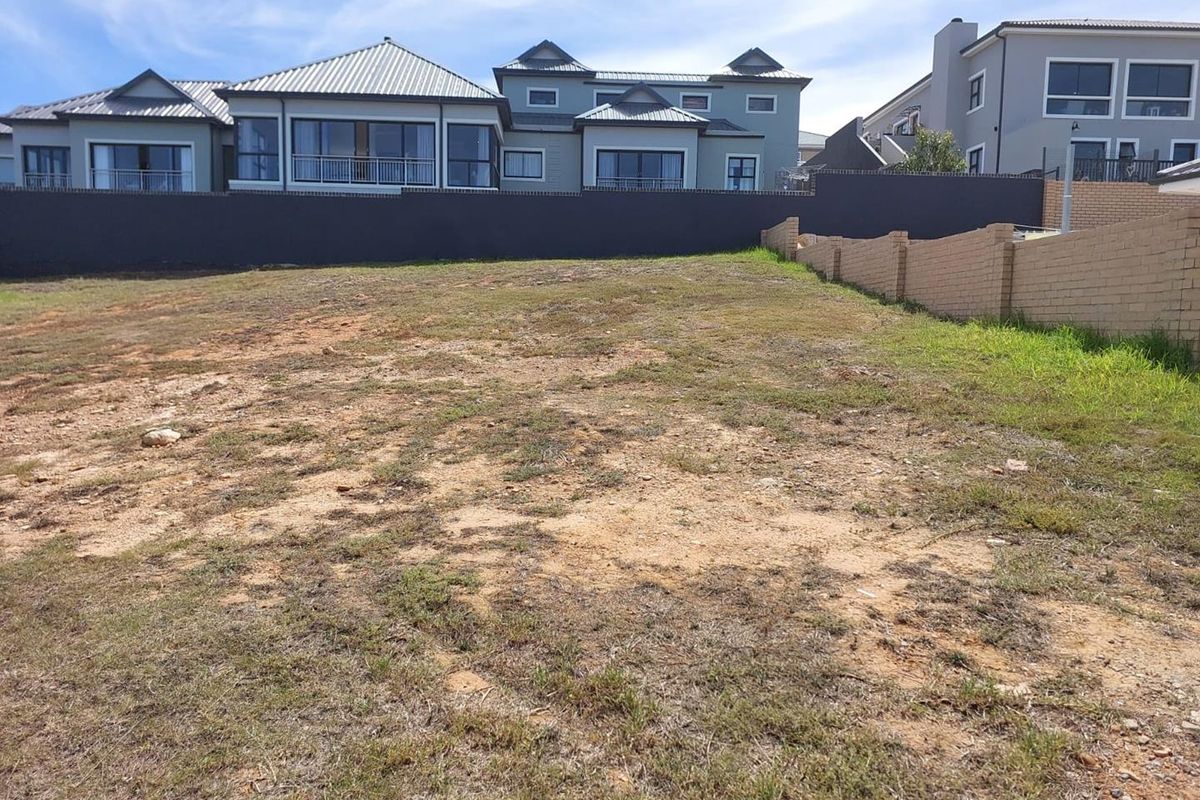 A vacant residential plot featuring a gentle slope, enclosed by perimeter boundary walls, situated within an established residential neighborhood.