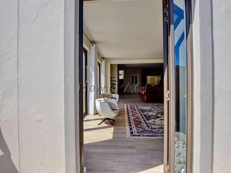 A bright living area featuring laminate flooring and large sliding glass doors that provide seamless access to the outdoor patio space.