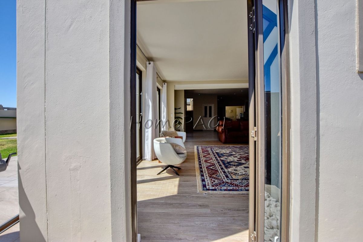 A bright living area featuring laminate flooring and large sliding glass doors that provide seamless access to the outdoor patio space.