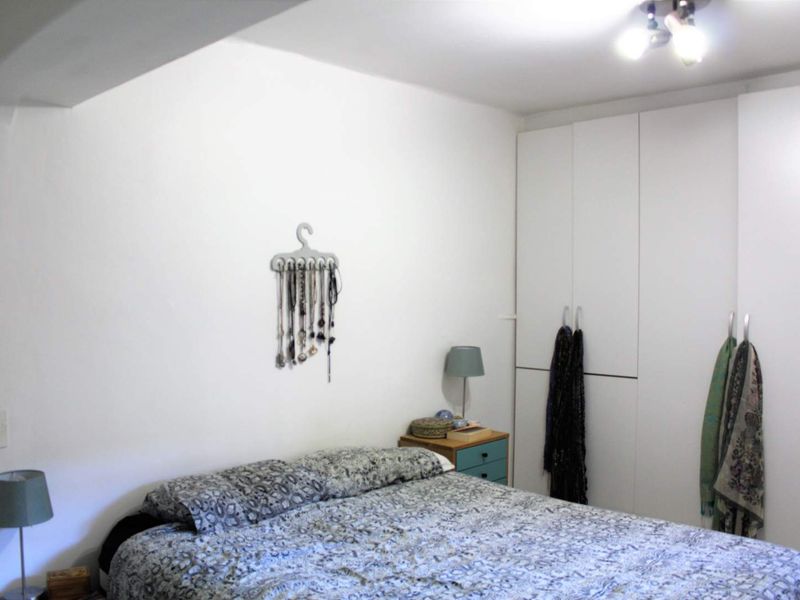 A functional bedroom featuring white built-in wardrobes and neutral wall finishes, providing ample storage space.