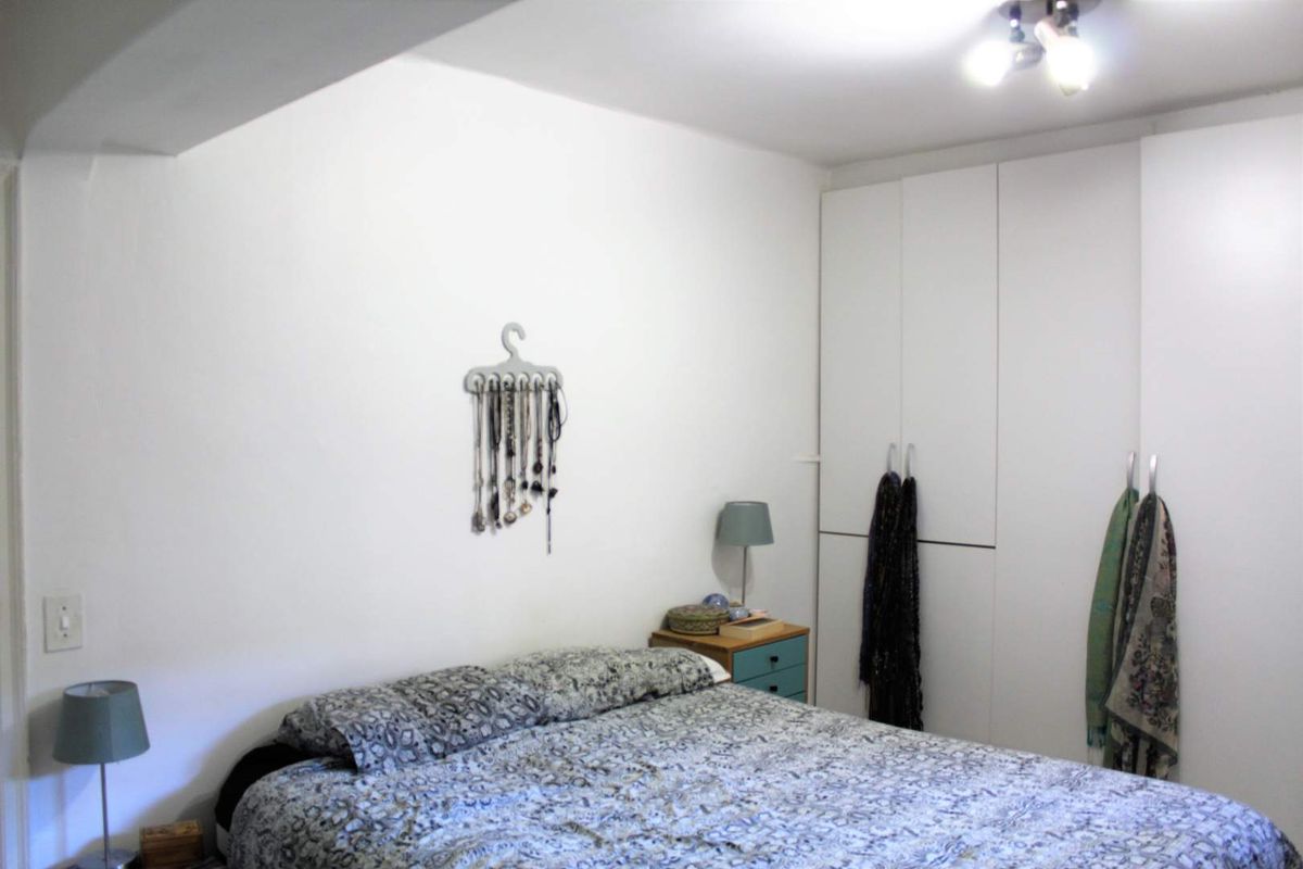 A functional bedroom featuring white built-in wardrobes and neutral wall finishes, providing ample storage space.