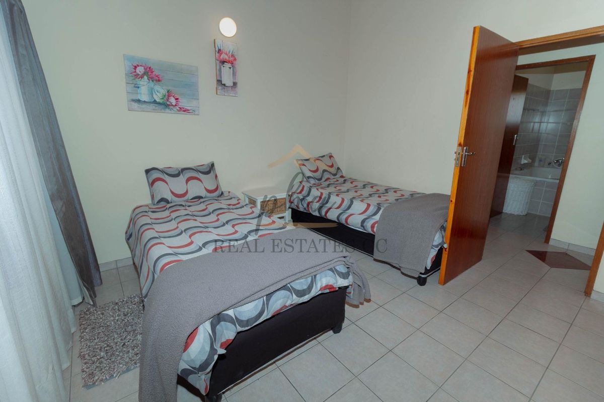 A functional bedroom featuring tiled flooring and direct access to an adjoining bathroom.
