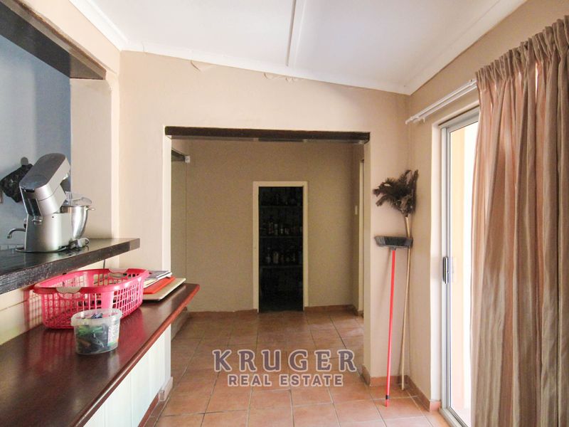 Open plan living area featuring tiled flooring, a built-in breakfast bar, and sliding glass door access to the exterior.