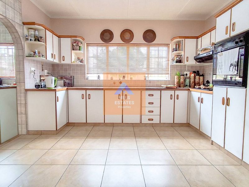 A functional kitchen featuring U-shaped cabinetry, tiled flooring, a built-in oven, and a tiled backsplash, offering a classic layout with ample storage space.