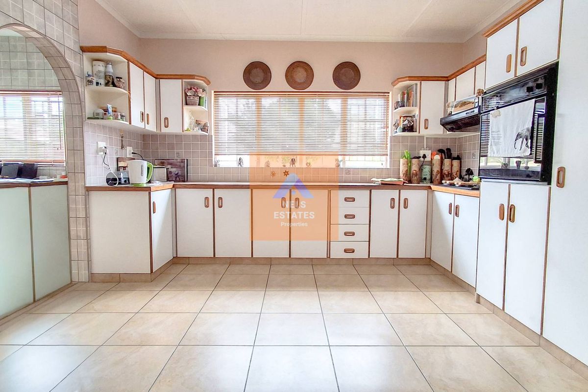 A functional kitchen featuring U-shaped cabinetry, tiled flooring, a built-in oven, and a tiled backsplash, offering a classic layout with ample storage space.