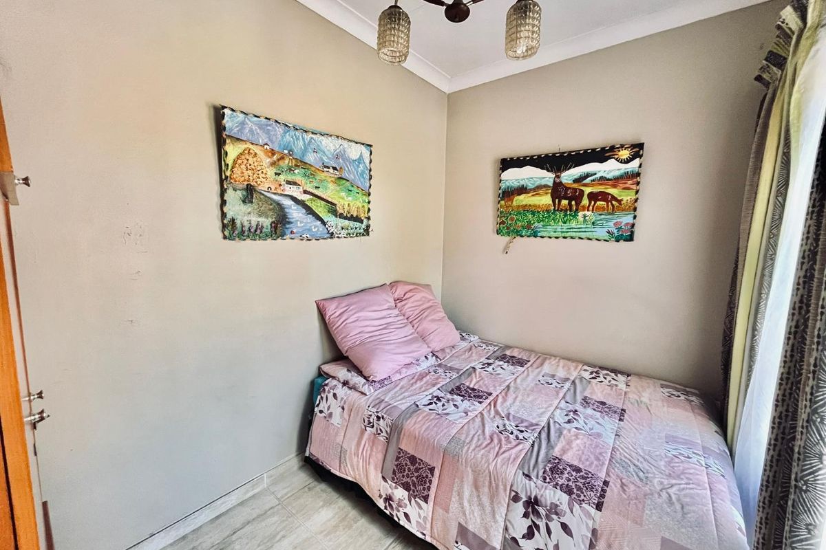 A compact bedroom featuring tiled flooring, neutral wall tones, and a central ceiling light fixture.