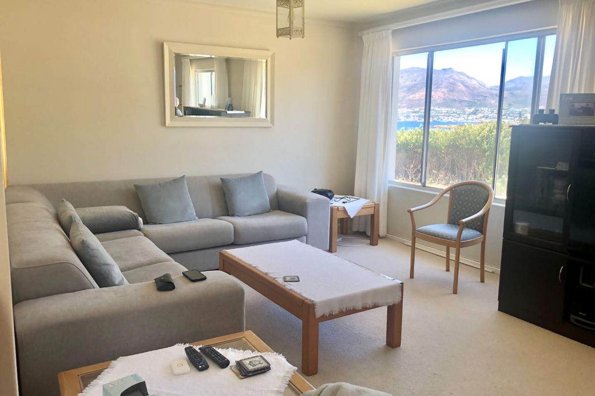A comfortable living room featuring large windows that provide natural light and scenic mountain and water views.