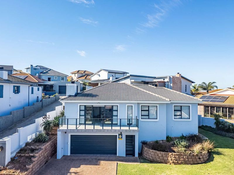 A well-maintained double-story residential property featuring a paved driveway, integrated double garage, and an elevated balcony with glass balustrades.
