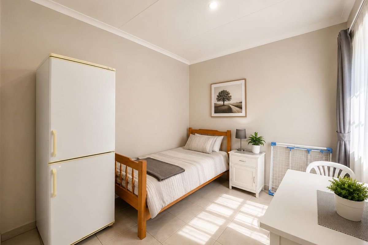 A well-maintained bedroom featuring neutral wall tones, tiled flooring, and recessed ceiling lighting, providing a clean and functional living space.