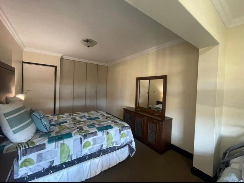 A bedroom featuring built-in cupboards, coving, and neutral wall finishes, providing a functional and well-proportioned sleeping space.