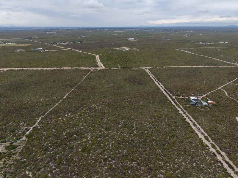 An aerial view of expansive, undeveloped agricultural land featuring natural vegetation and dirt access tracks throughout the property.