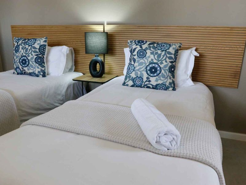 A well-maintained bedroom featuring a modern slatted timber headboard design.