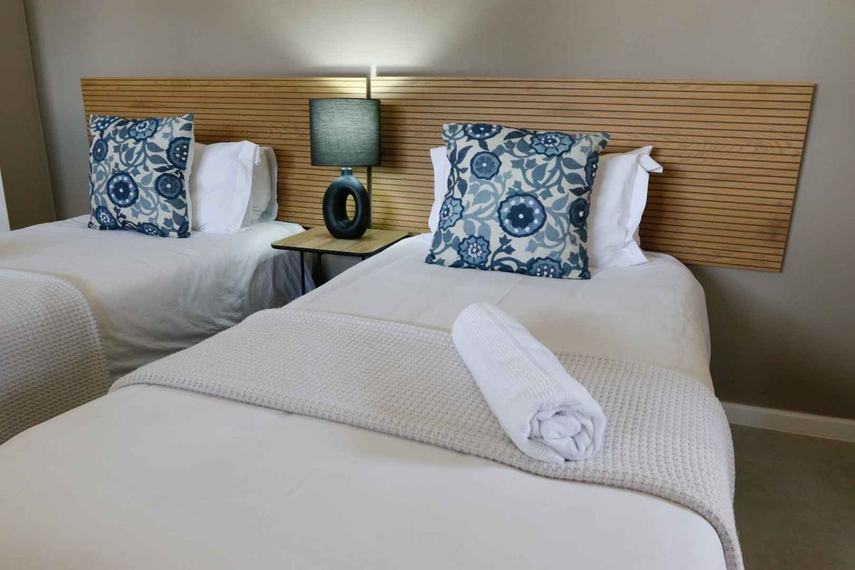 A well-maintained bedroom featuring a modern slatted timber headboard design.