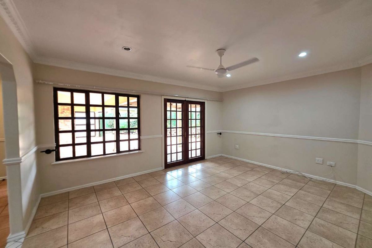 Spacious, empty living area featuring neutral tiled flooring, a ceiling fan, recessed lighting, and classic french doors leading to the exterior.