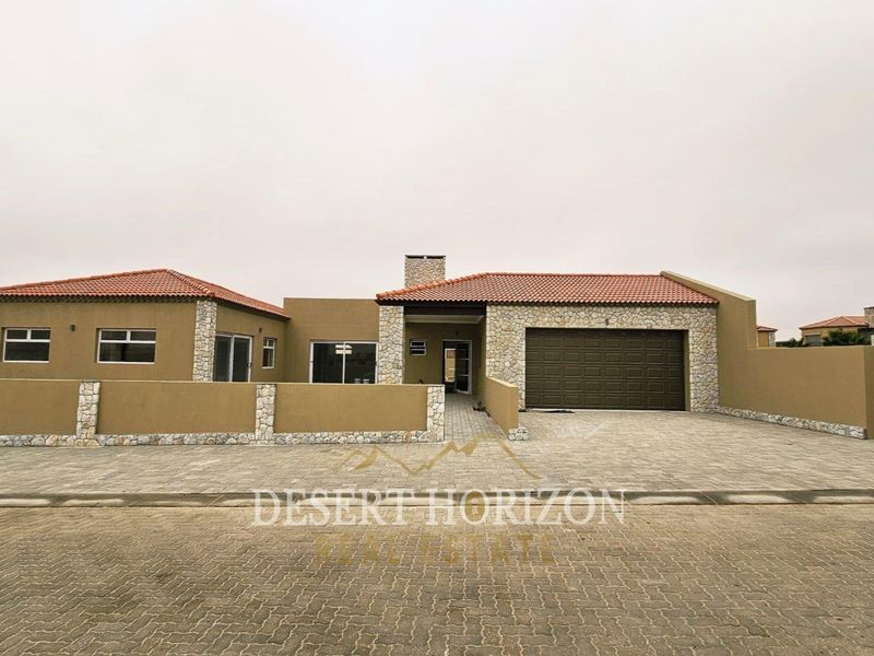 Front elevation of a modern single-story house featuring stone cladding, terracotta roof tiles, a paved driveway, and an integrated double garage.