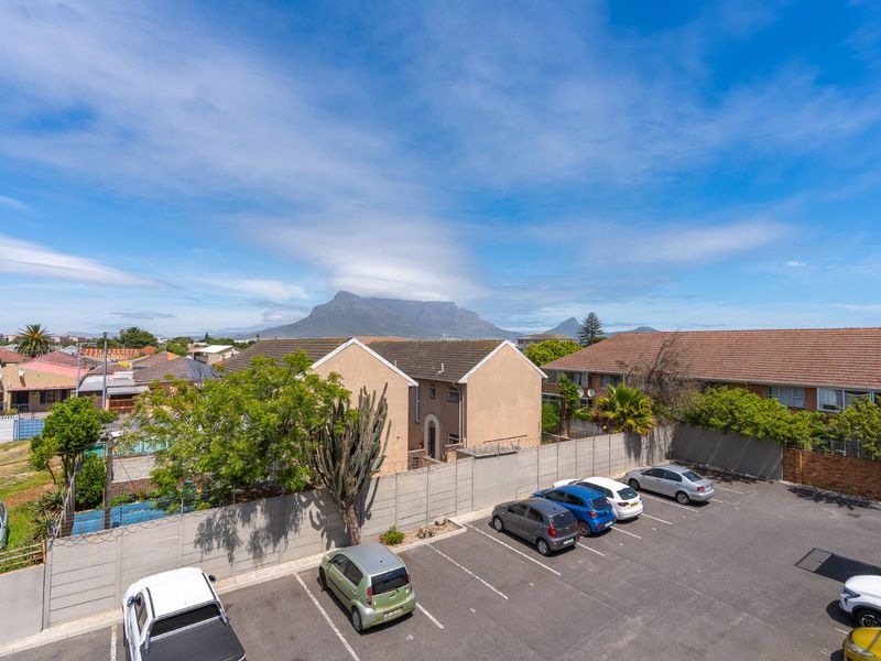 Elevated view overlooking the apartment complex parking area with Table Mountain visible in the background.
