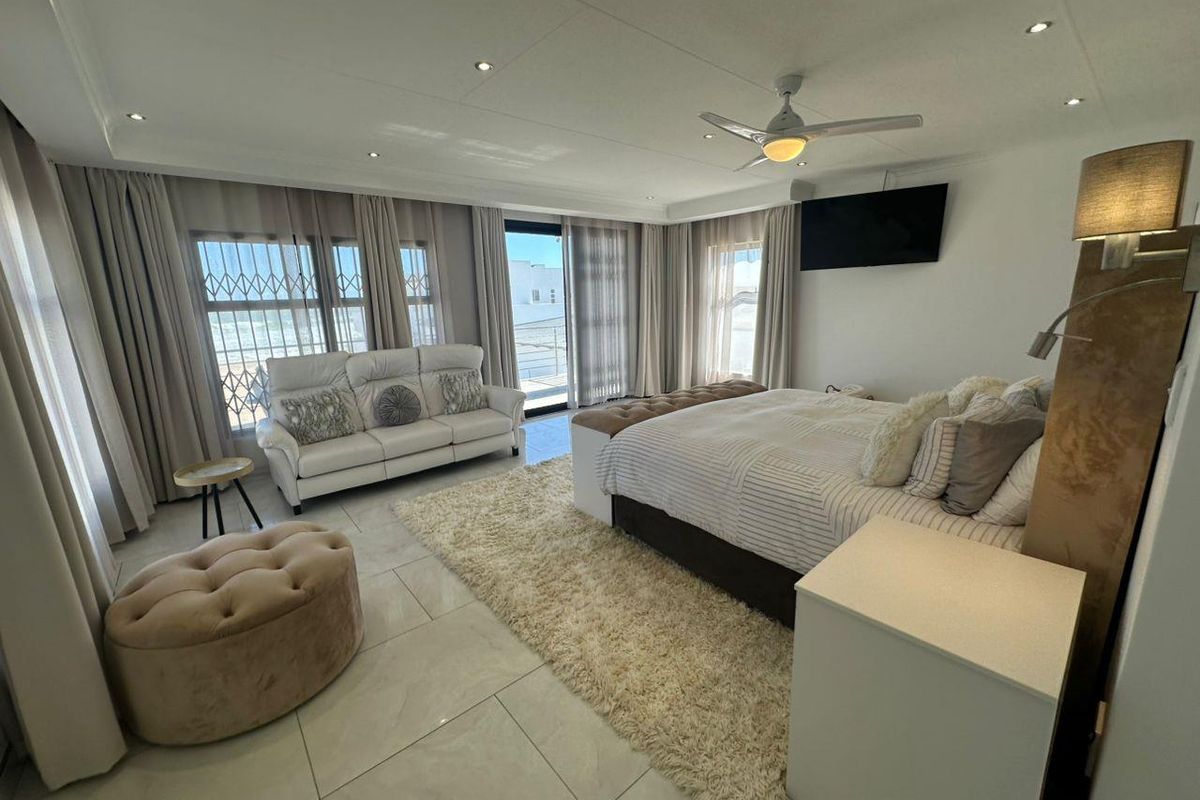 Spacious bedroom featuring tiled flooring, recessed downlighting, a ceiling fan, and large sliding glass doors providing access to an outdoor area.