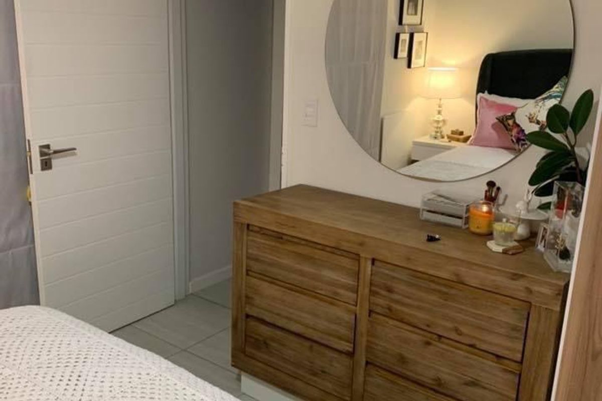 A well-maintained bedroom featuring tiled flooring, a modern internal door, and built-in storage solutions.