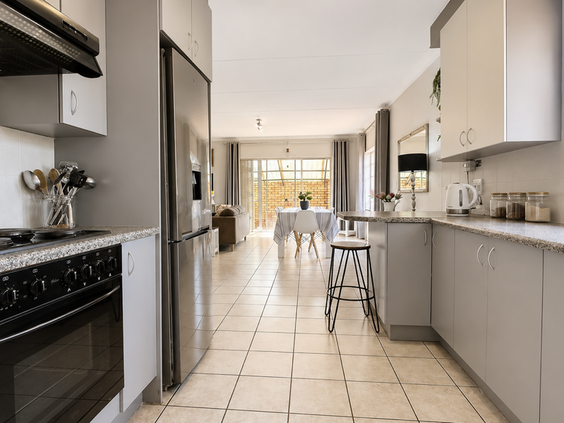Modern open-plan kitchen featuring sleek cabinetry, granite countertops, and integrated appliances, flowing seamlessly into the dining and living areas.