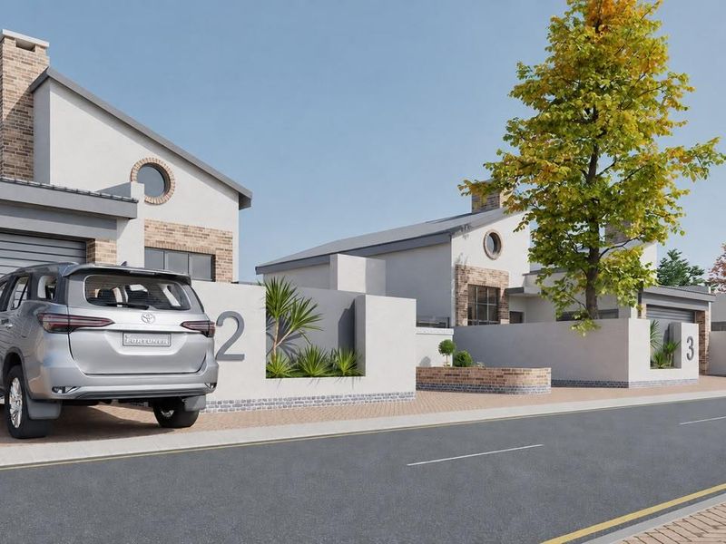 A modern townhouse exterior featuring a paved driveway, garage, and architectural brick detailing along the street-facing facade.