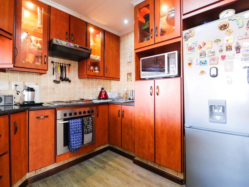 A functional kitchen featuring warm-toned wooden cabinetry, granite countertops, a built-in oven, and a tiled backsplash, offering a classic and practical cooking space.