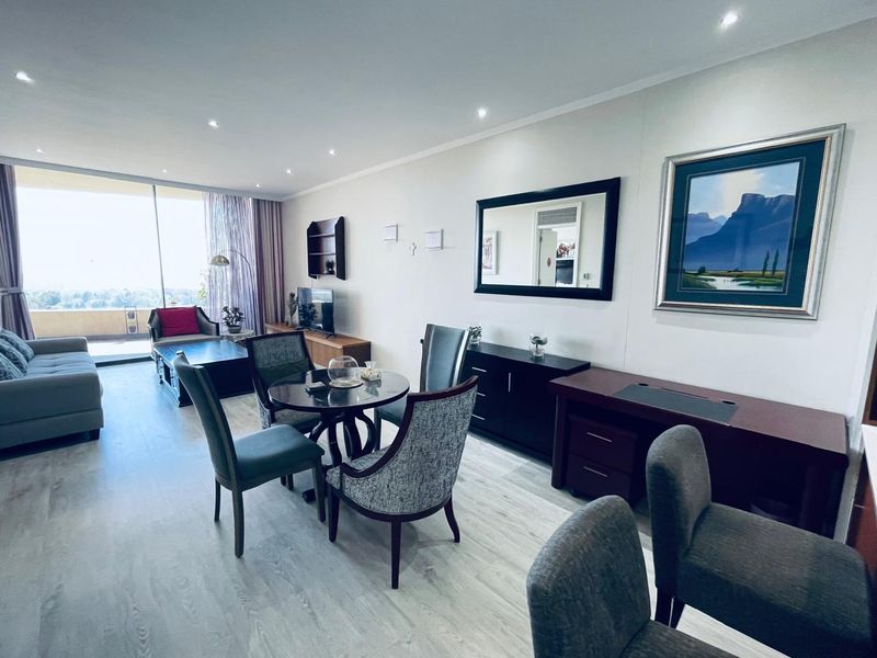 Spacious open-plan living and dining area featuring modern laminate flooring, recessed lighting, and large sliding glass doors leading to a balcony.