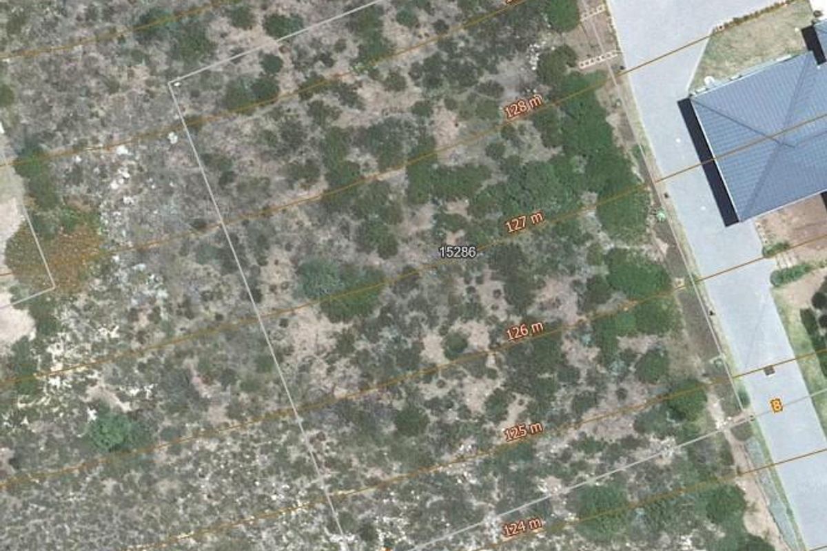 An aerial view of a vacant residential plot featuring natural vegetation and clear boundary markings for potential development.