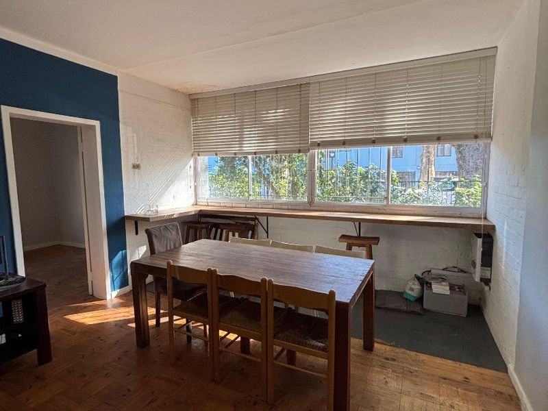 Dining area featuring classic parquet flooring, an exposed brick wall, and a built-in window counter with natural light.