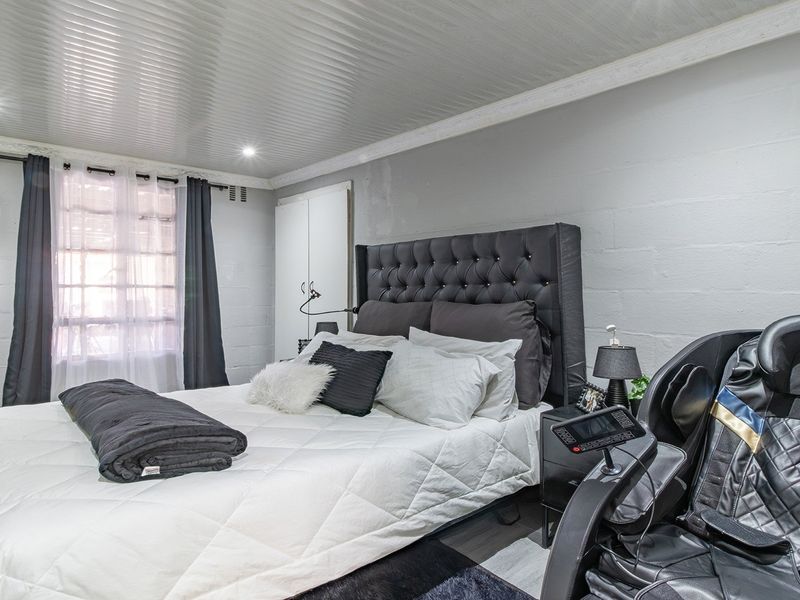 A bedroom featuring a coved ceiling, recessed downlighting, laminate flooring, and a built-in wardrobe.