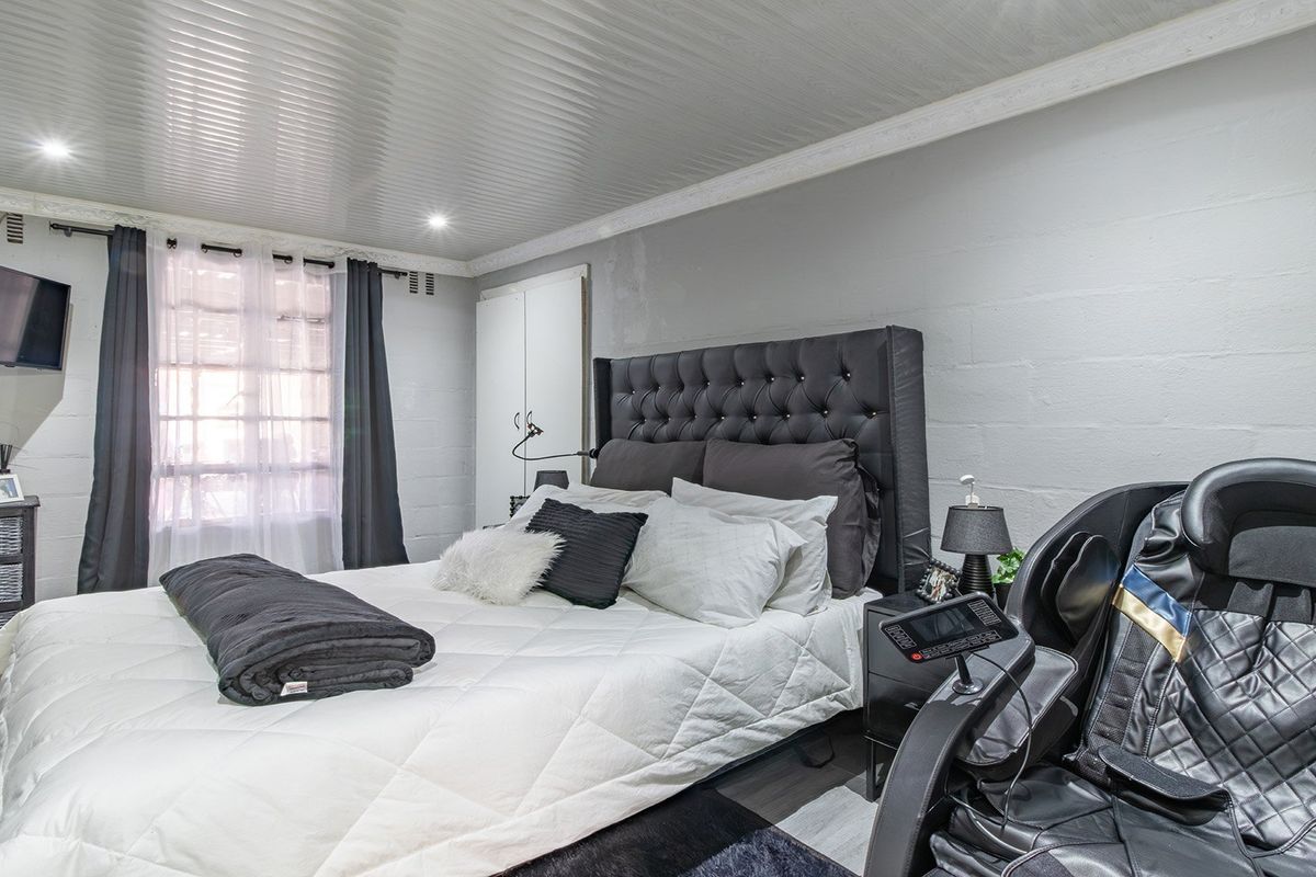 A bedroom featuring a coved ceiling, recessed downlighting, laminate flooring, and a built-in wardrobe.