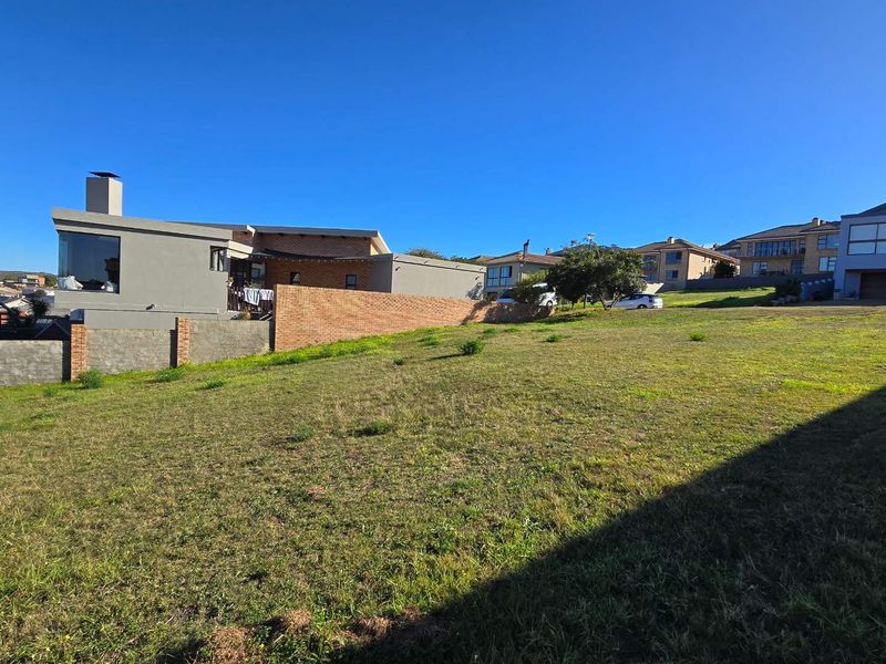 A vacant residential plot of land featuring established boundary walls and surrounding residential properties in a developed neighborhood.