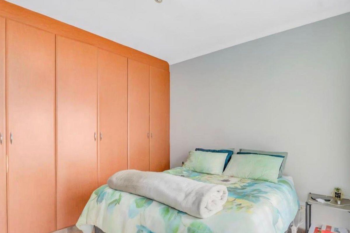 A bedroom featuring built-in wooden cabinetry providing ample storage space, with neutral wall finishes and standard flooring.