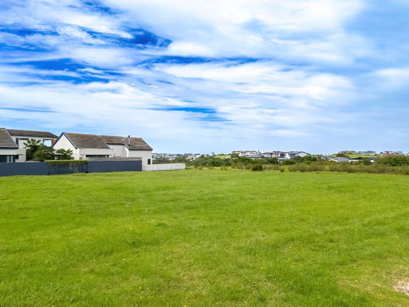 A spacious, well-maintained residential plot featuring a level grass lawn and established boundary fencing in a quiet neighborhood setting.