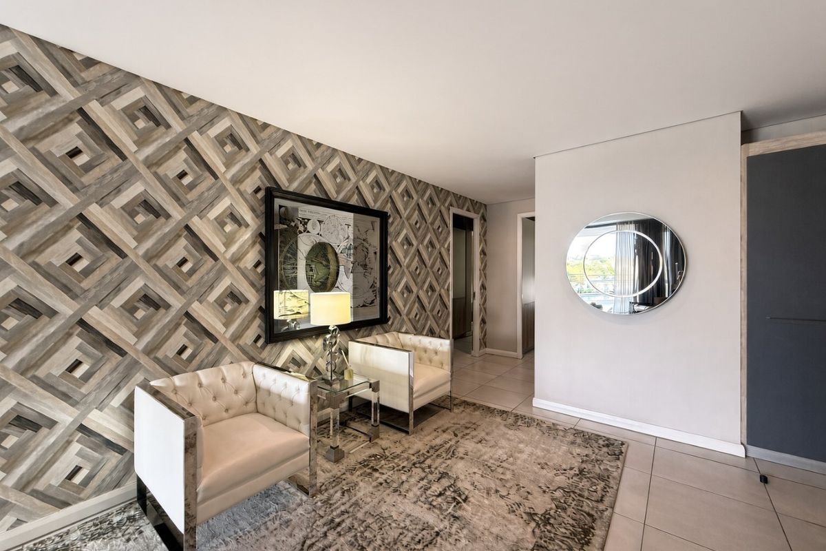A well-maintained living area featuring modern tiled flooring and a striking geometric feature wallpaper, creating a sophisticated and inviting atmosphere.