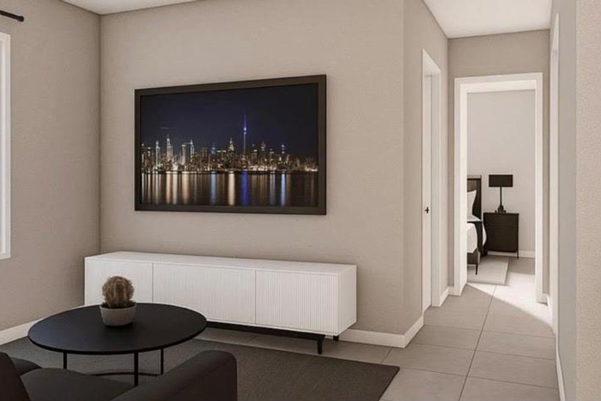 A modern living area featuring neutral wall tones, large windows, and tiled flooring, leading into a hallway with access to an adjacent bedroom.