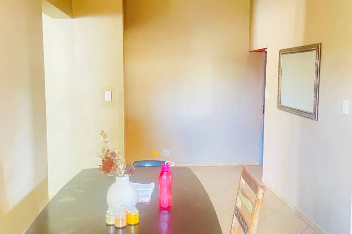 A dining area featuring tiled flooring and neutral wall tones, offering a functional space ready for potential cosmetic updates.