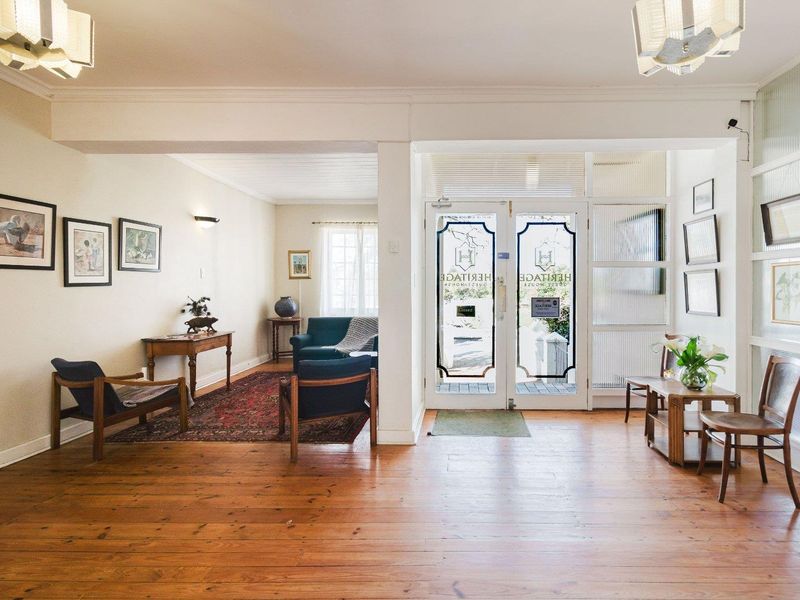 Welcoming entrance foyer featuring polished hardwood flooring, double glass doors with decorative detailing, and bright, open-plan layout leading into the main reception area.