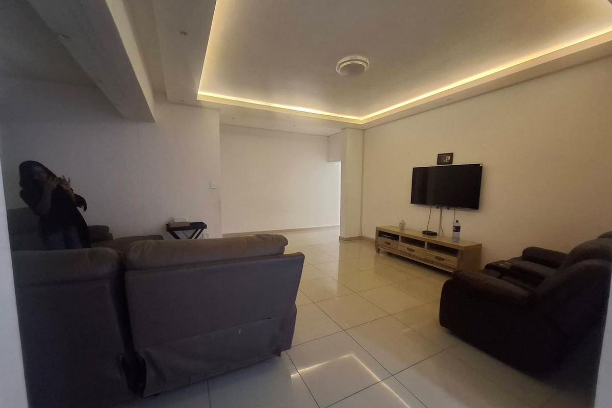 A spacious living room featuring modern recessed ceiling lighting and neutral tiled flooring, providing a clean and bright foundation for living space.