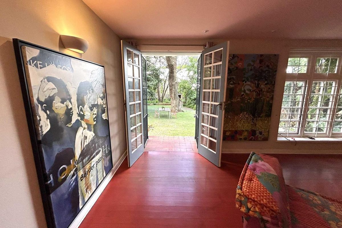 Living room featuring painted timber flooring and French doors opening onto a private rear garden.