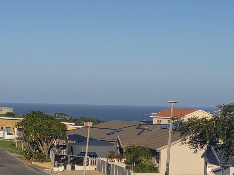 A clear, elevated view of the ocean horizon overlooking the surrounding residential neighborhood and rooftops.