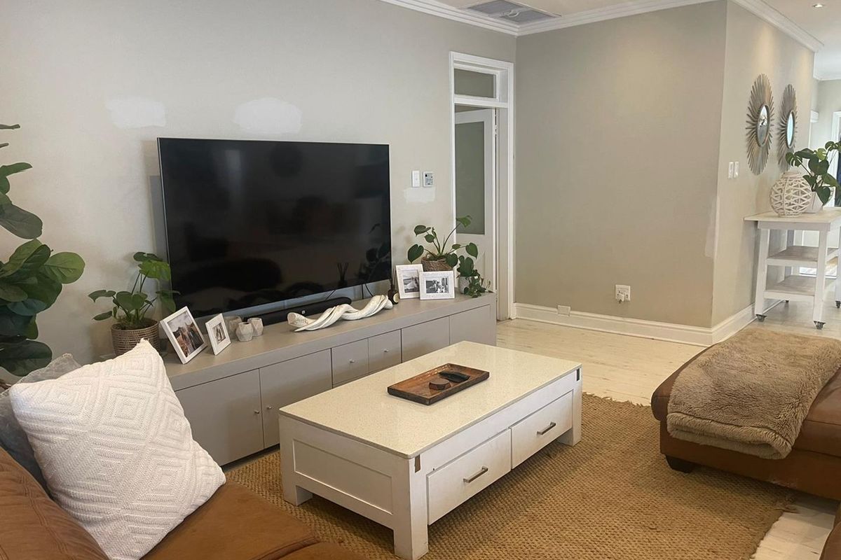 A comfortable living room featuring neutral wall tones, crown molding, and recessed lighting, providing a versatile space for relaxation.