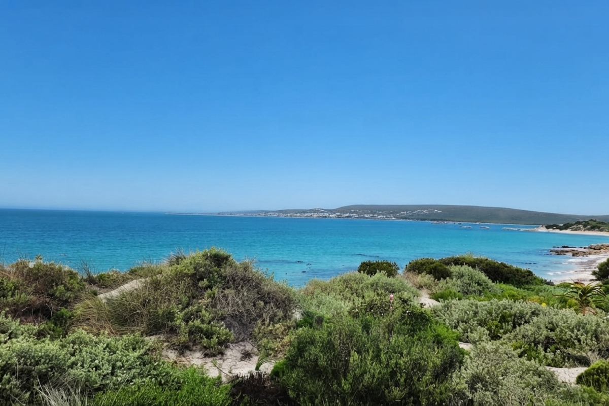 A scenic coastal view overlooking the ocean and natural vegetation, showcasing the prime location of this vacant residential land.