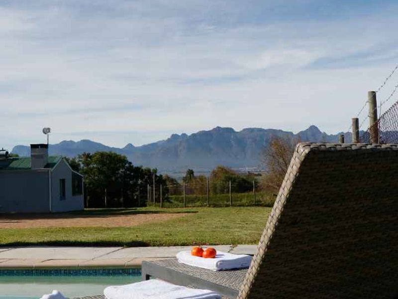 Outdoor pool area featuring a swimming pool with concrete coping, overlooking a scenic mountain landscape.