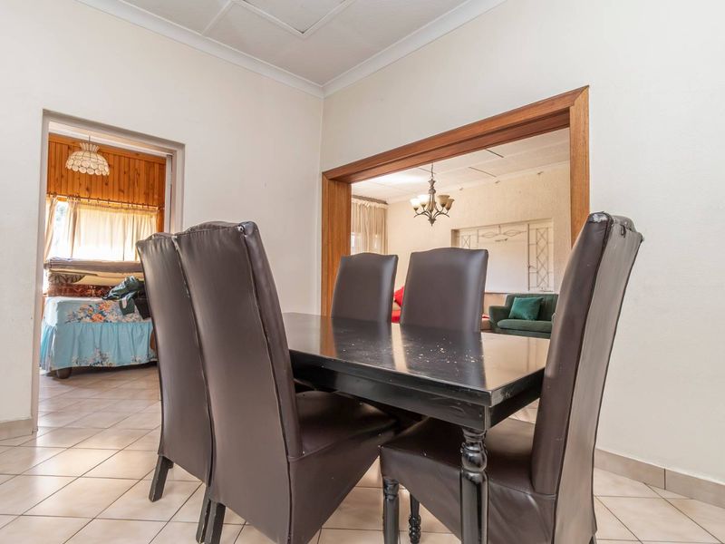 Dining area featuring tiled flooring and a timber-framed opening leading to an adjacent living space.