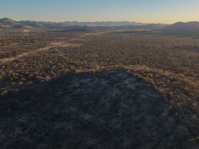 An expansive aerial view of the surrounding natural landscape and rugged terrain, showcasing the vast open space and scenic horizon.