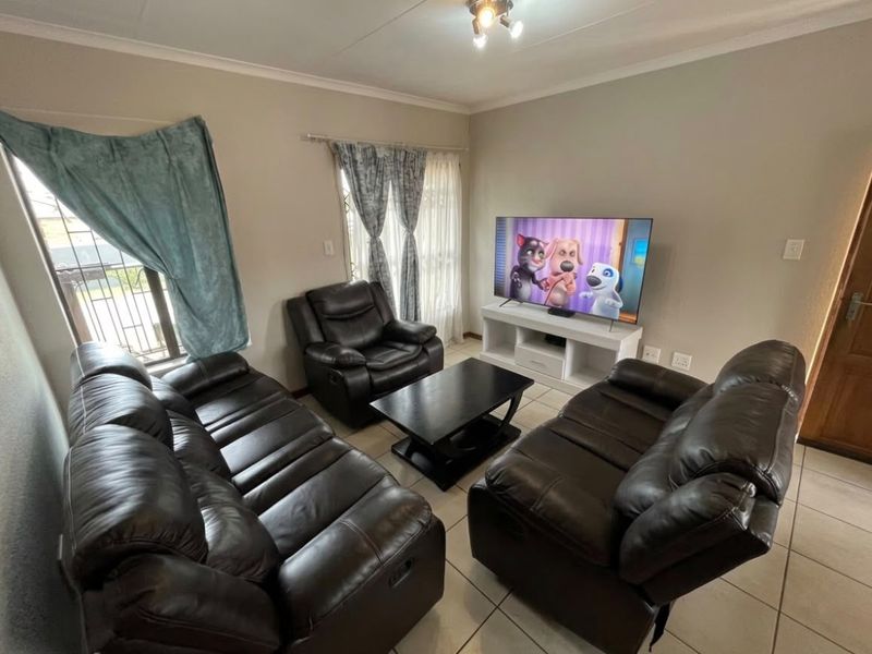 A comfortable living room featuring tiled flooring, security gates on windows, and decorative cove cornicing, providing a functional and well-lit space.
