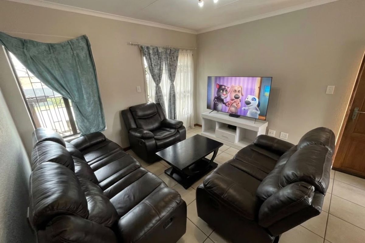 A comfortable living room featuring tiled flooring, security gates on windows, and decorative cove cornicing, providing a functional and well-lit space.
